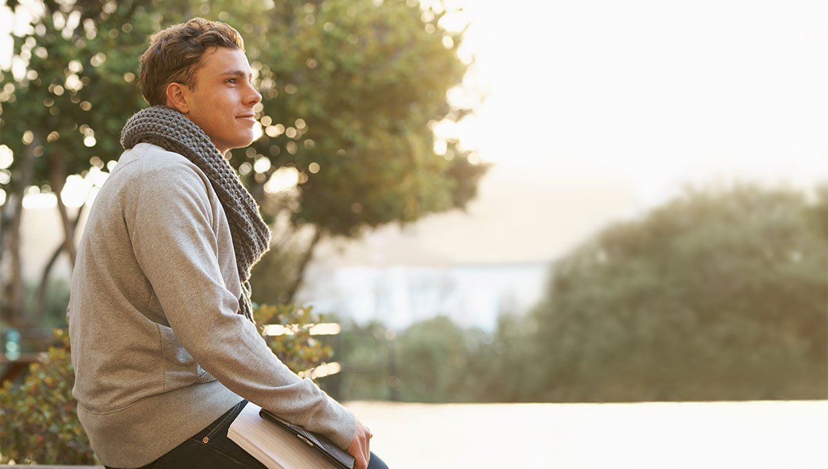 Student leaning on a bench