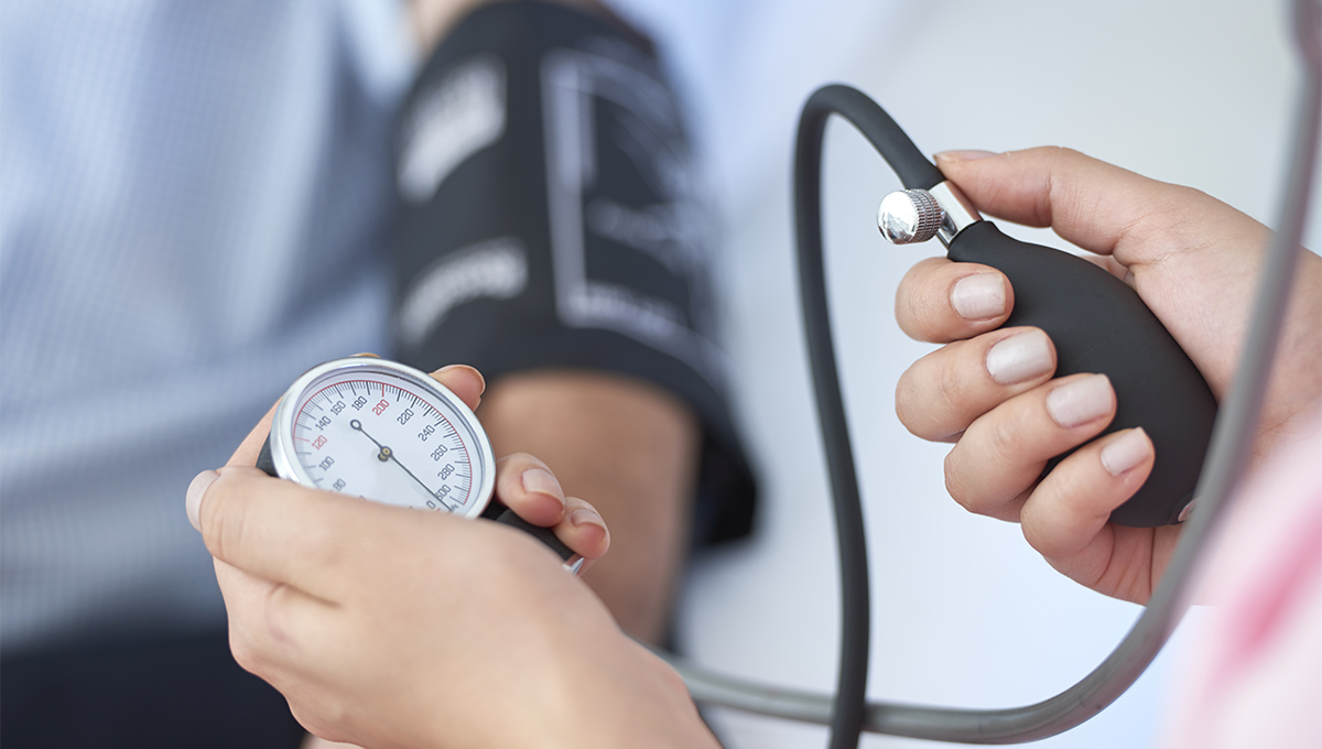 Hands using a blood pressure machine