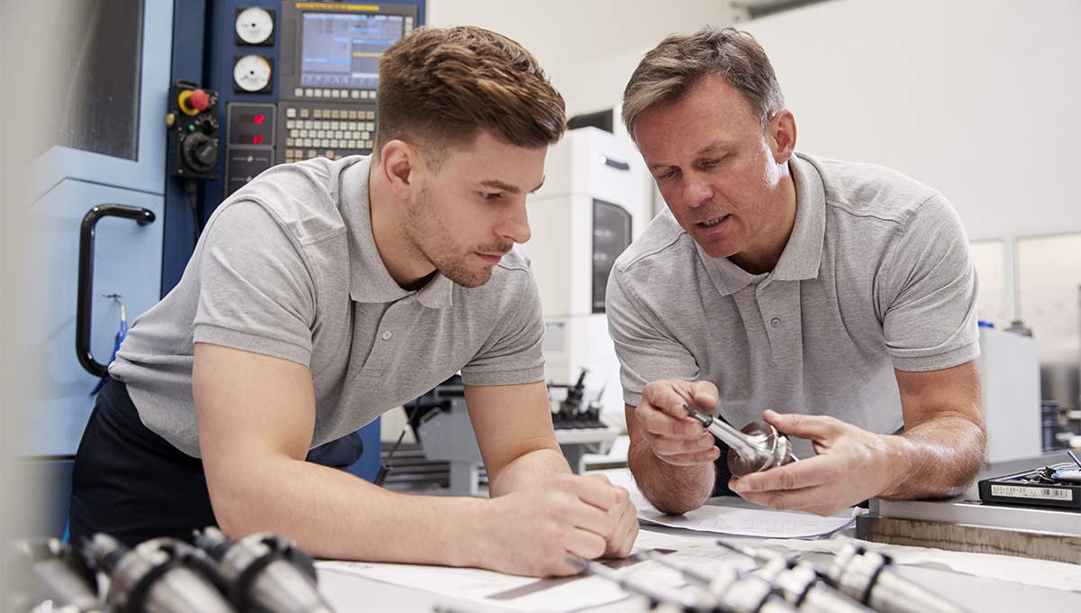 Teacher helping engineering apprentice